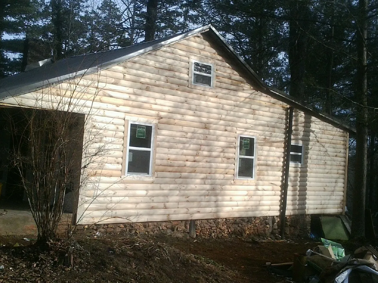 New log siding and dark metal roofing on a gable end in Continental