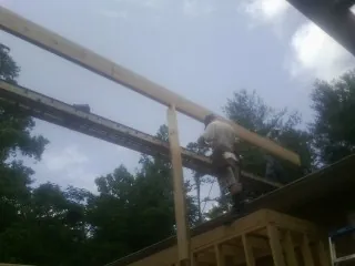 Carpenter setting a ridge beam over a new addition frame — Ice Dam Removal by Roofing Brothers in Continental