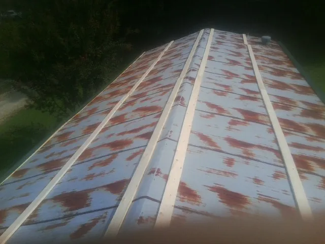 Rusted metal roof panels with new wood purlins before replacement — Storm Damage Roof Repair in Continental by Roofing Brothers