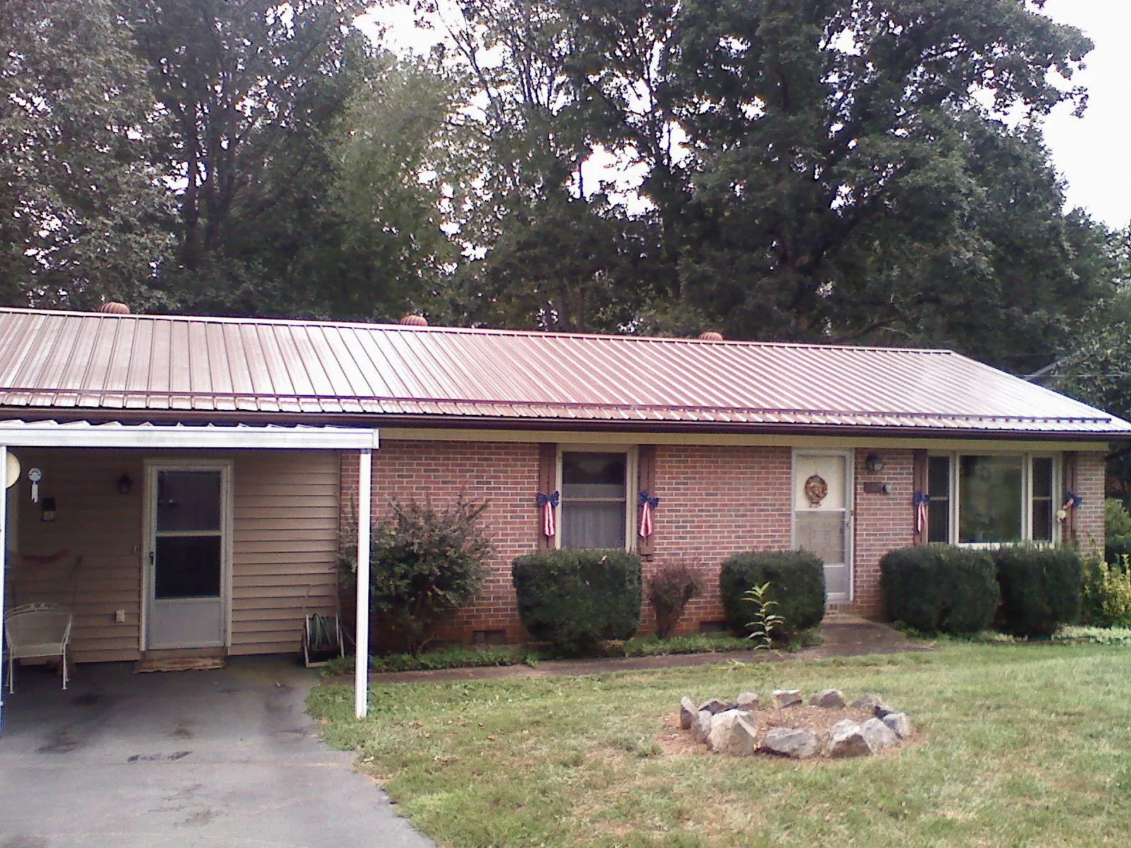 Bronze metal roof and carport on a brick ranch home — Roof Repair work by our crew in Continental